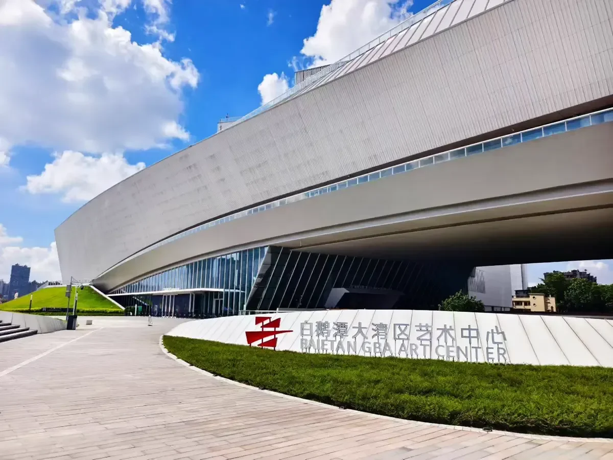 Daytime view of the southern arrival plaza showing the white ceramic ship hull and red official center emblem