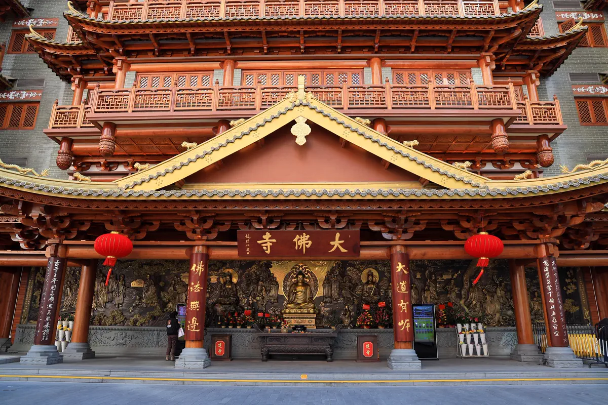 Entrance gatehouse of Dafo Temple with carved timber eaves, red lanterns and golden Buddhist statues