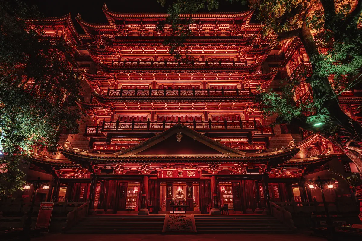 Low angle view of illuminated red and golden eaves of Dafo Temple glowing brightly in the evening