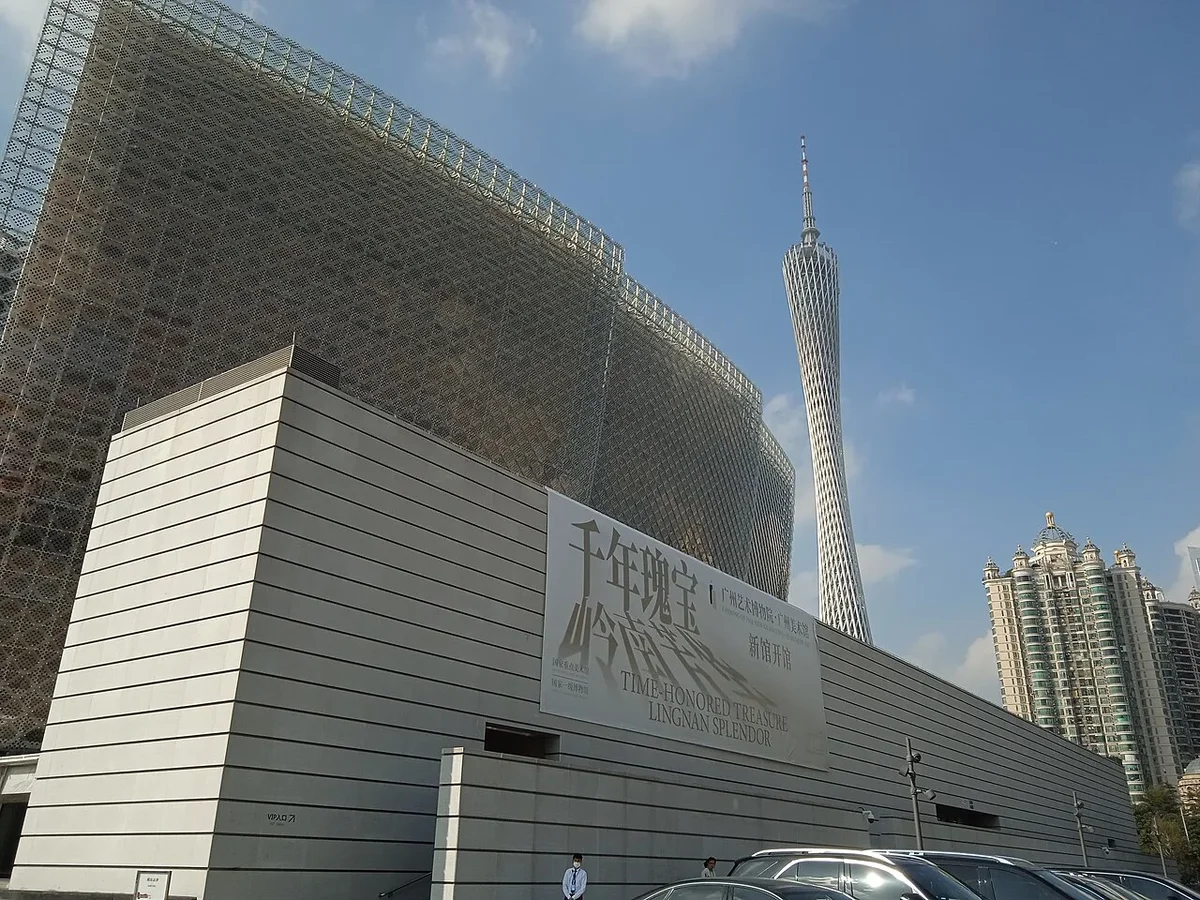 Exterior entrance banner wall displaying exhibition titles with Canton Tower towering overhead