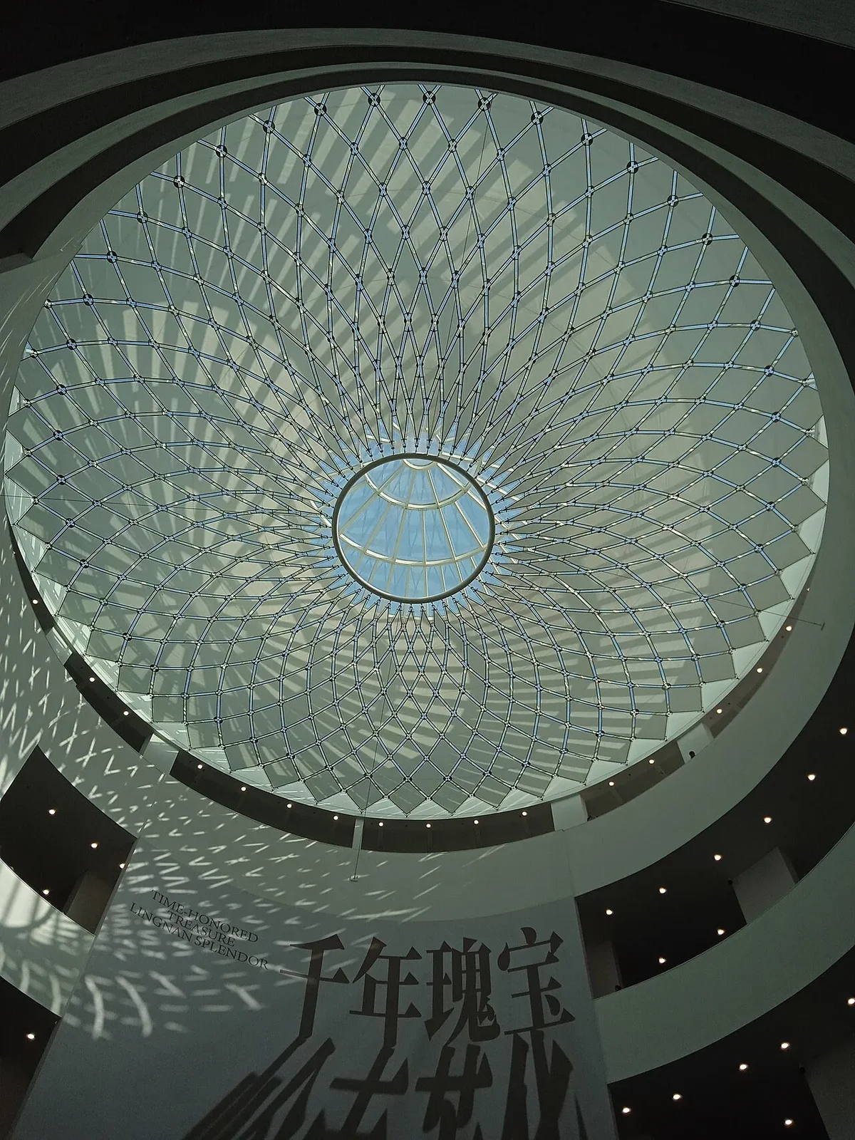 Upward perspective of the forty-meter central light atrium showing geometric shadows cast by the glass dome