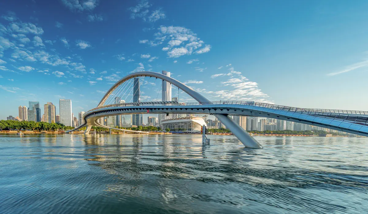 Panoramic view of Haixin Bridge spanning the Pearl River under clear blue skies with Zhujiang New Town skyscrapers in the background