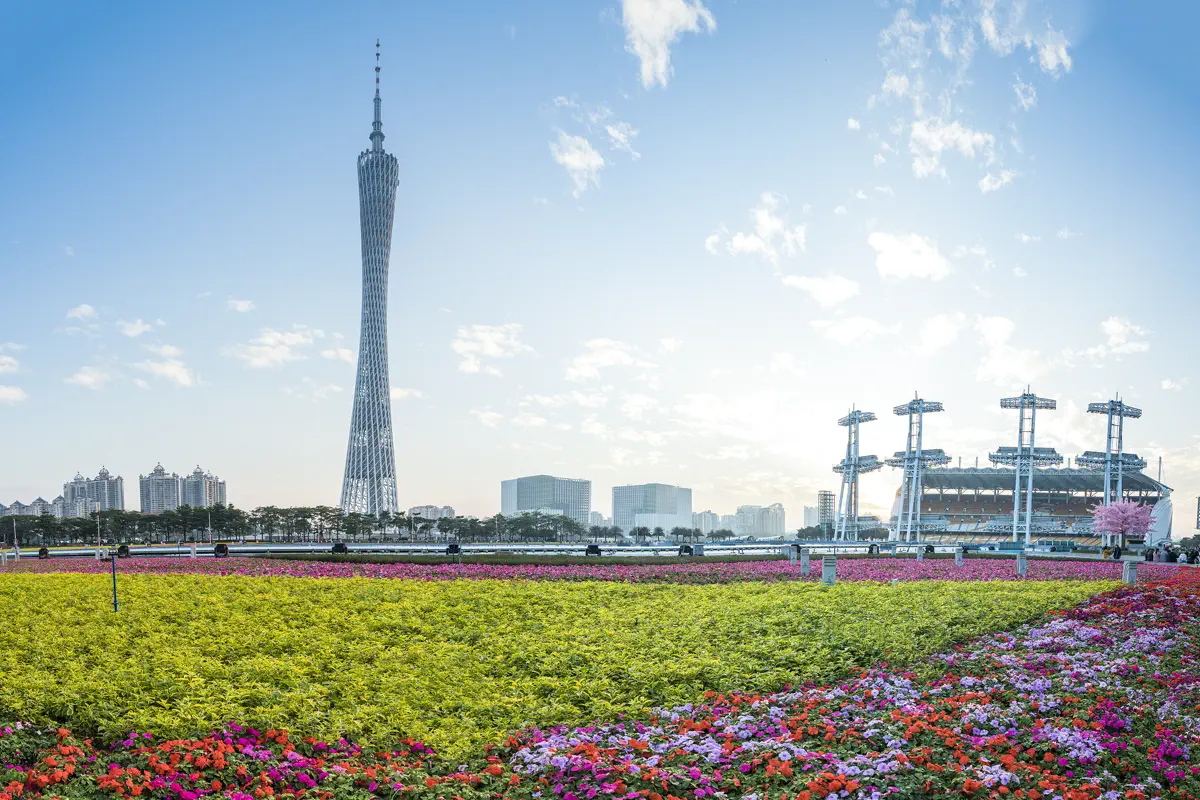 Vibrant blooming flower meadows on Haixinsha Island with the Asian Games steel sail masts and Canton Tower