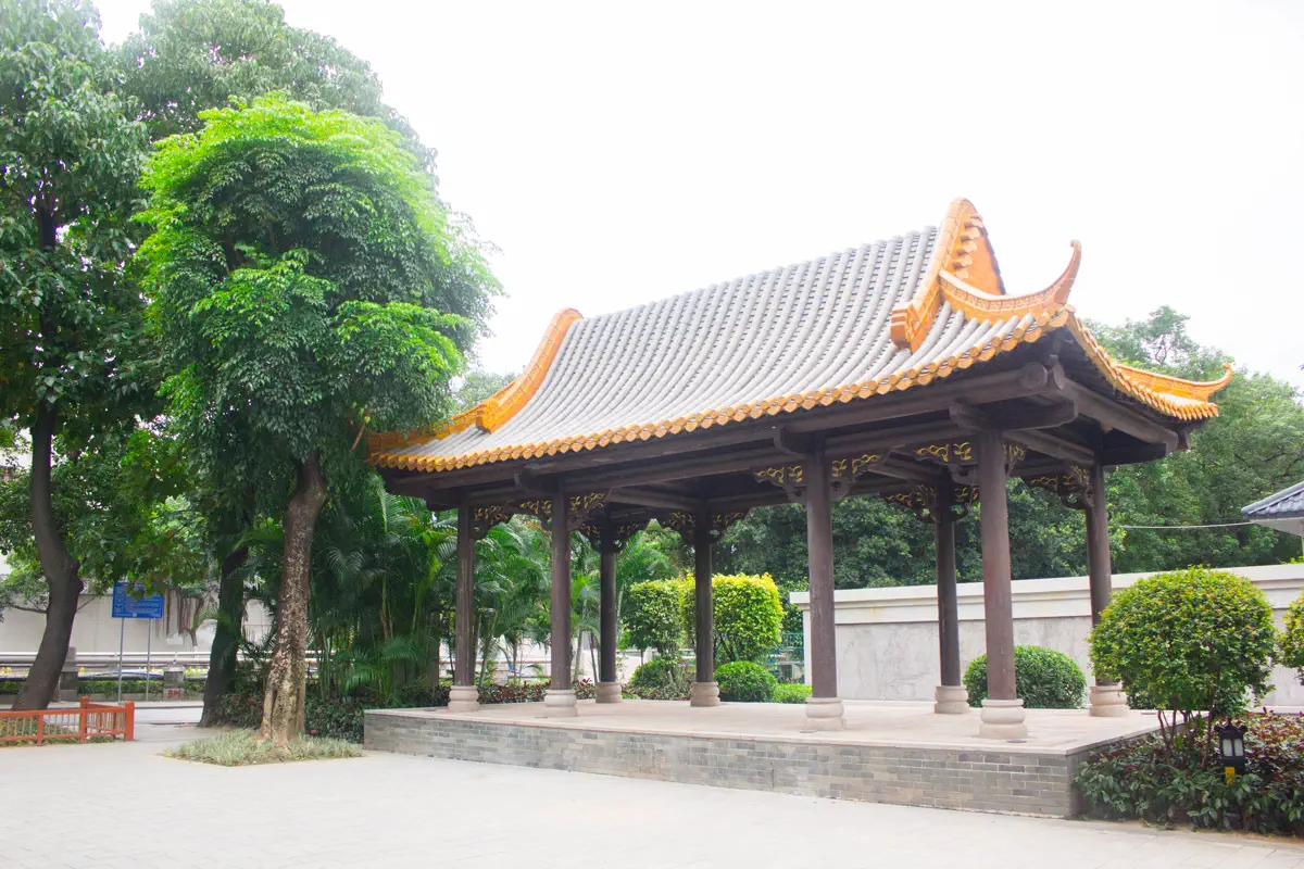 Traditional hip-and-gable timber pavilion with curved eaves on the community square of Julong Village