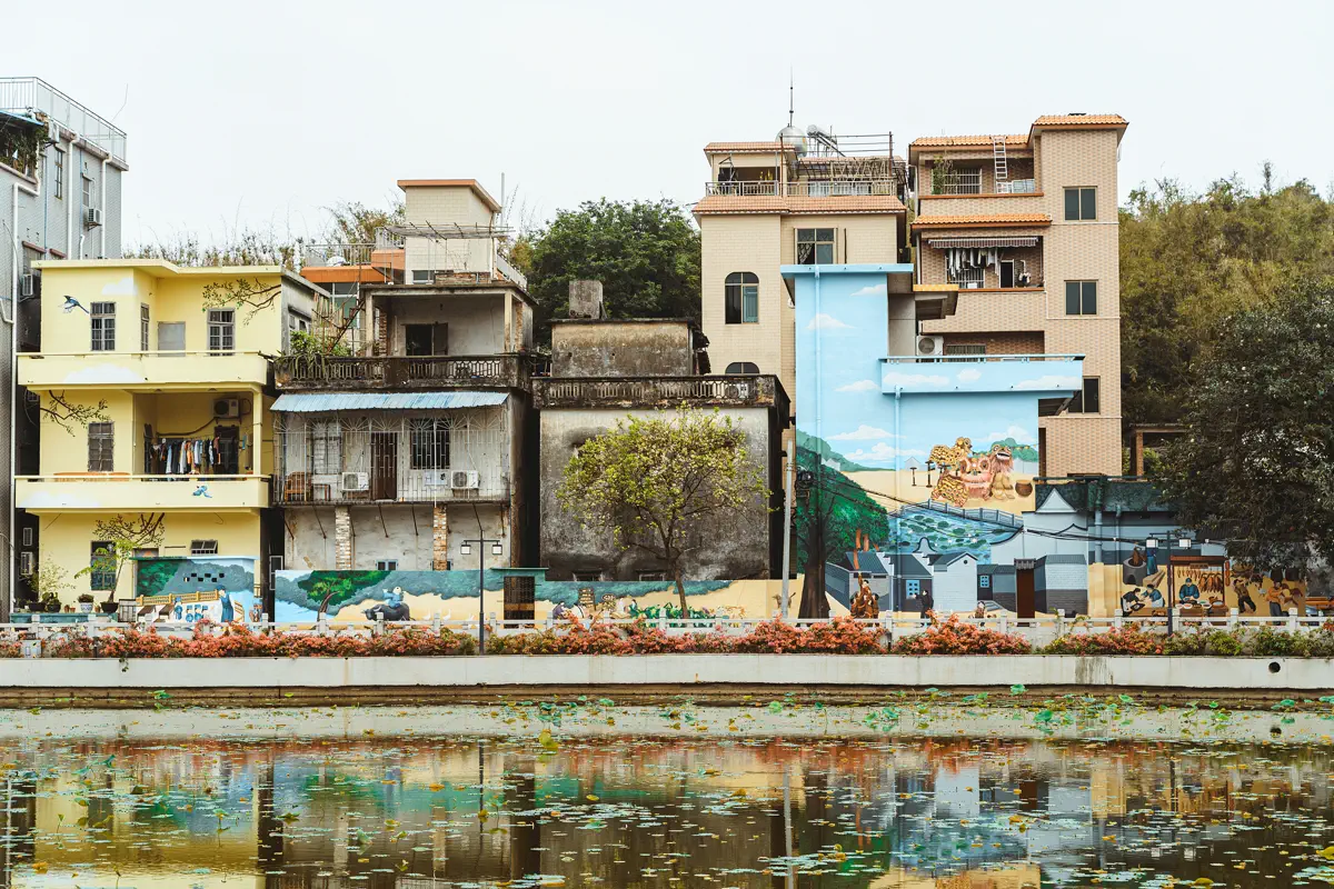 Village homes and colorful murals reflected on the lotus pond of Shenjing Village
