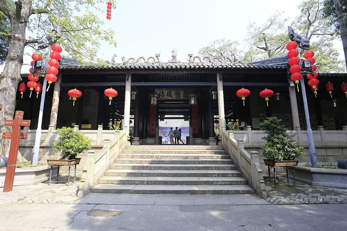 Stone steps and open courtyard of Yimen gate with hanging red lanterns and Shiwan pottery ridge ornaments