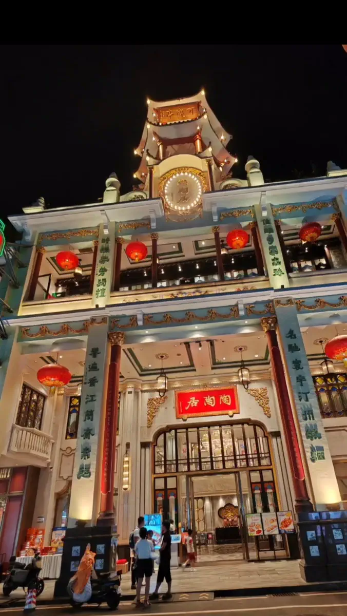 Night view of the historic Tao Tao Ju tea house flagship with illuminated sign and Republican-era arcade facade on Dishifu Road