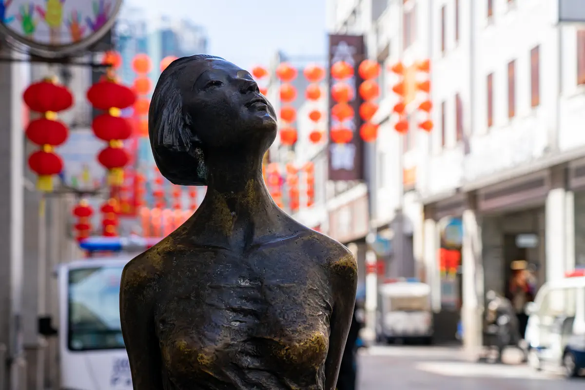 Bronze statue representing historic Xiguan folk culture along the Shangxiajiu arcade walkway