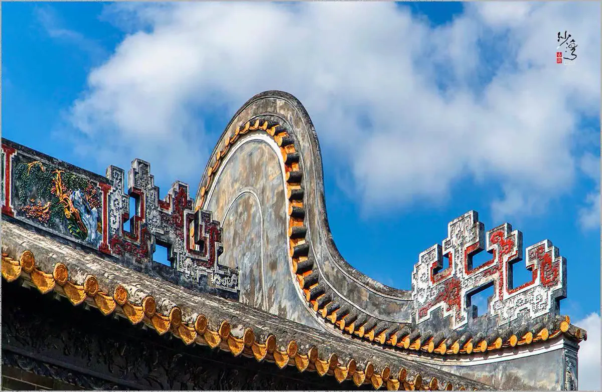 Lingnan wok-ear gable walls with detailed lime plaster sculptures against a clear blue sky