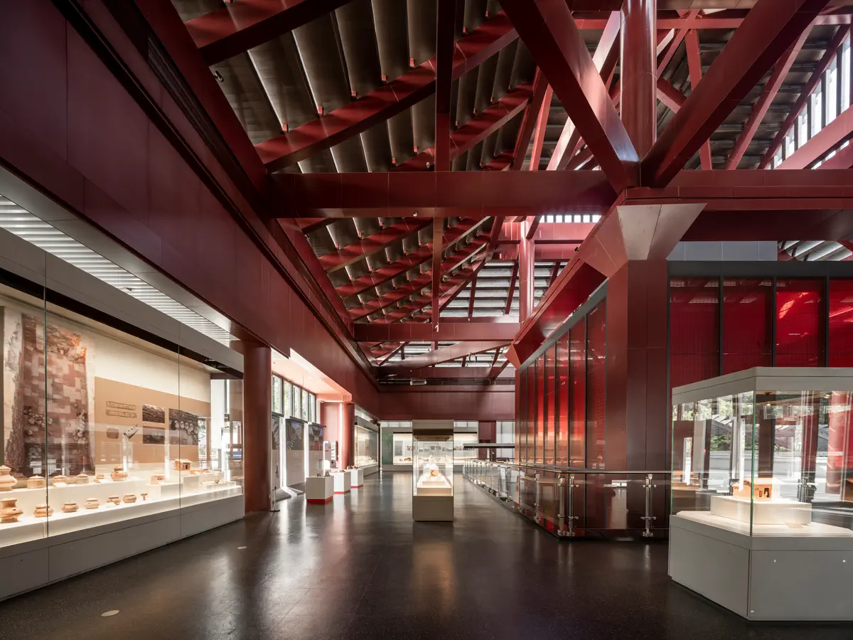 Spacious interior exhibition hall of Southern Han Mausoleums Museum with red steel trusses and modern glass display cases