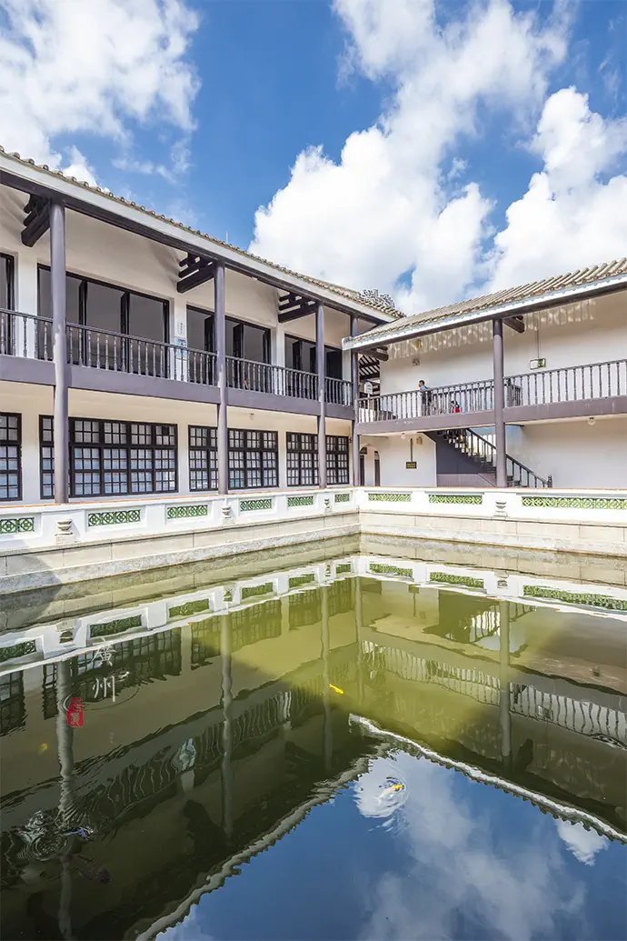 Traditional two-storey quadrangle courtyard of Whampoa Military Academy with covered verandas reflecting over a stone pond