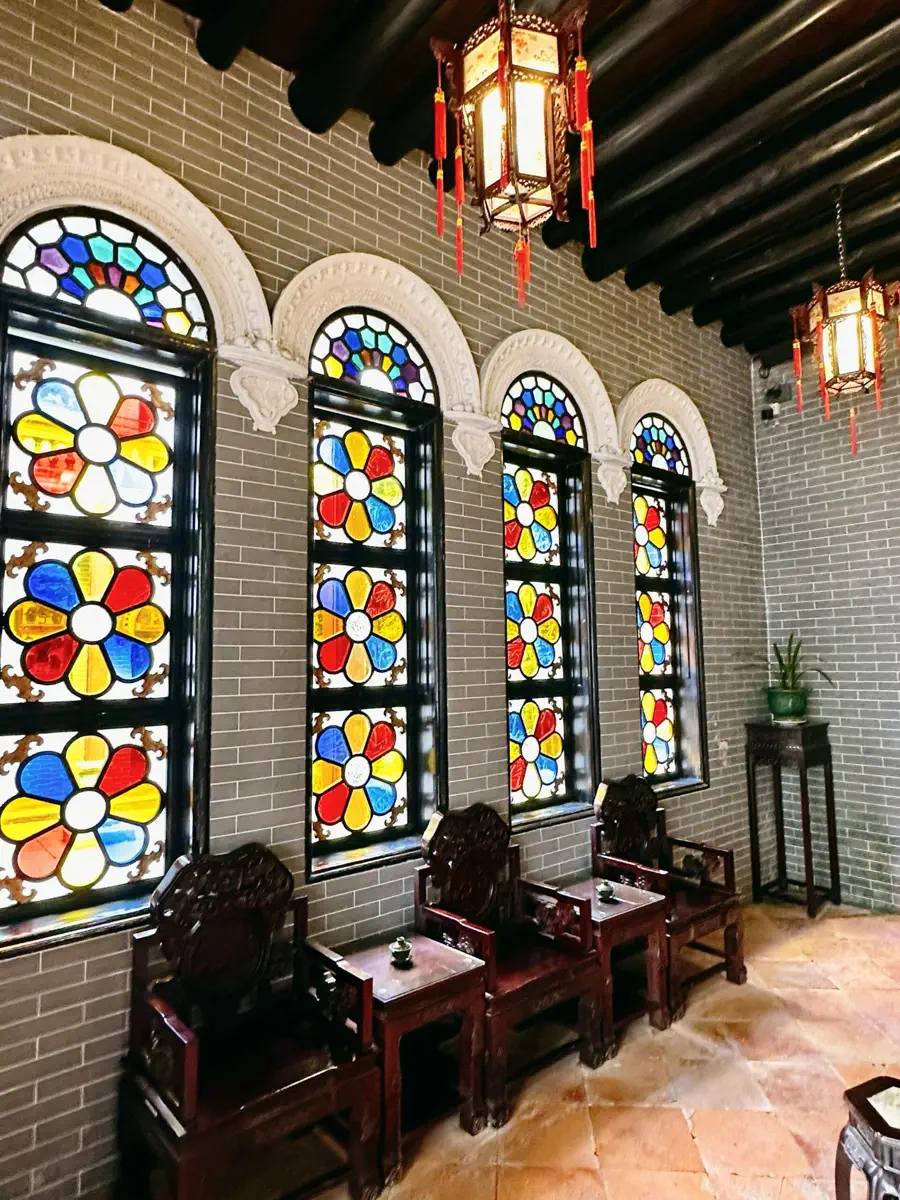 Classical Lingnan hall in Shenliu Hall featuring arched Manchurian stained-glass windows, water-polished blue brick walls, and rosewood armchairs